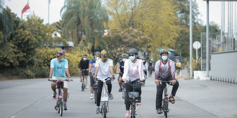 People riding bicycle on road during daytime in Jakarta, Indonesia.