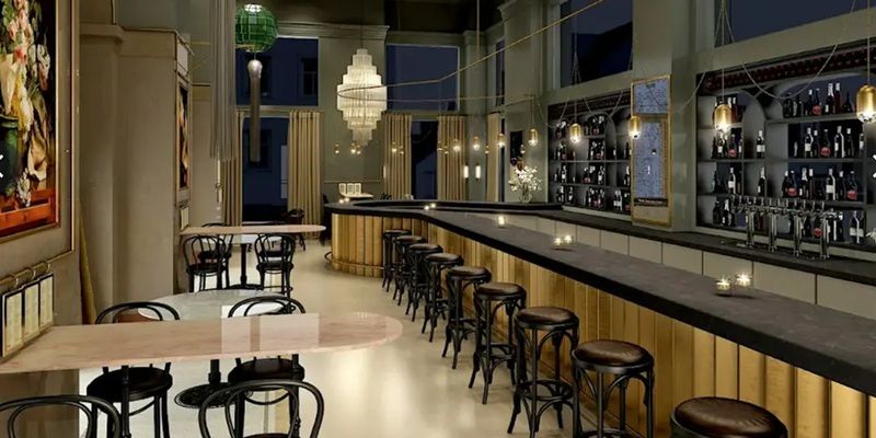 The inside of a fancy bar, complete with tables, chairs and mood lighting.