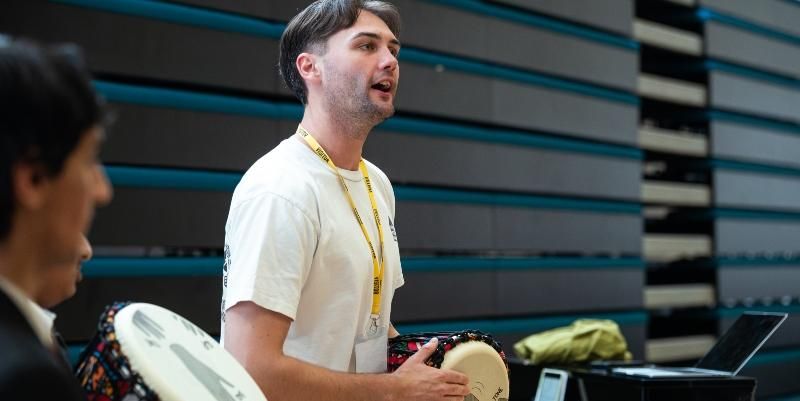 Zane Berghuis bangs a drum as part of a music workshop.