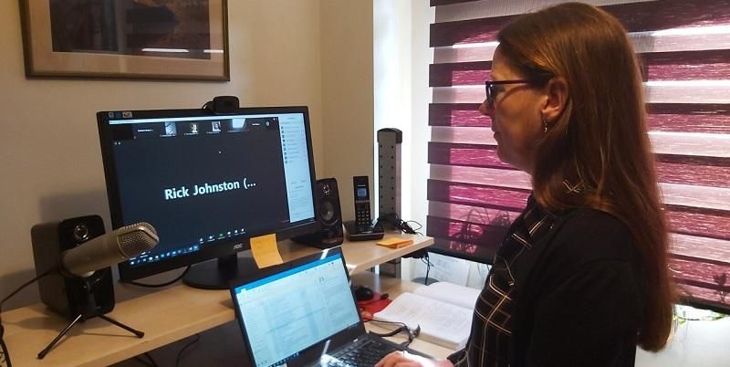 The image shows Professor Barbara Evans hosting the virtual conference from a computer in her office.