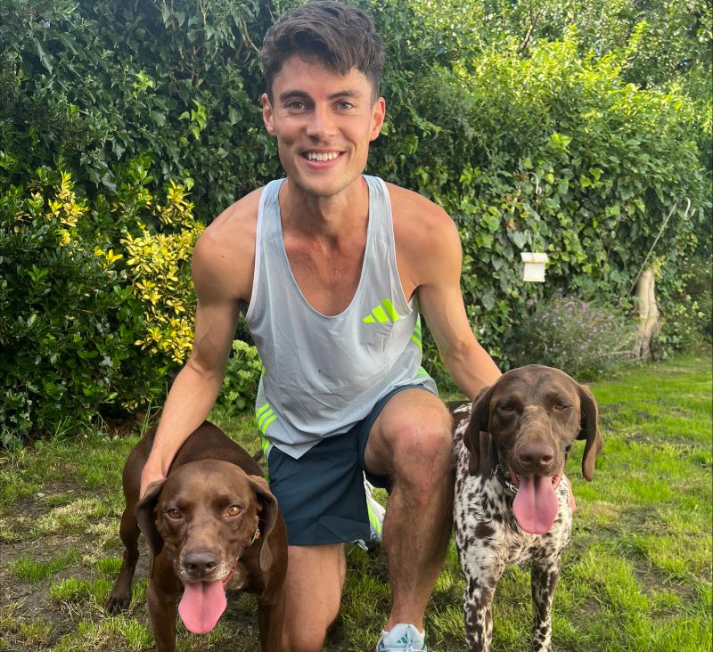 Phil Sesemann kneels with his dogs for a picture