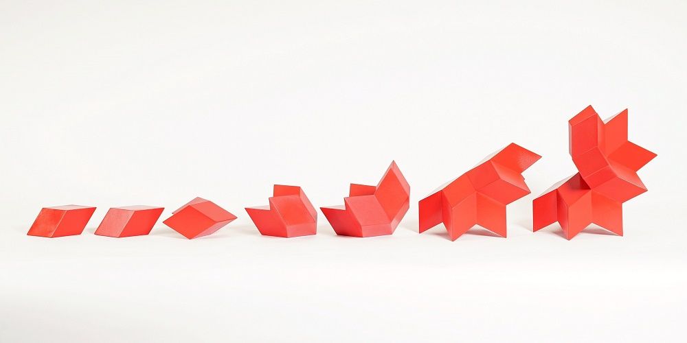 A series of red sculptural forms in a line