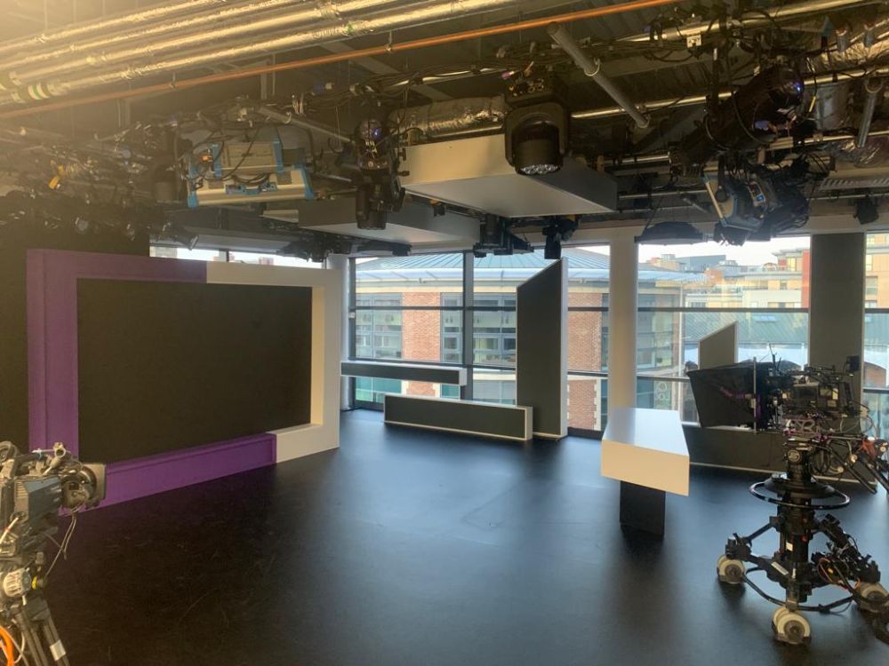 The Channel 4 News set in Leeds, featuring a camera on a tripod in the foreground and the big screen at the rear of the shot.