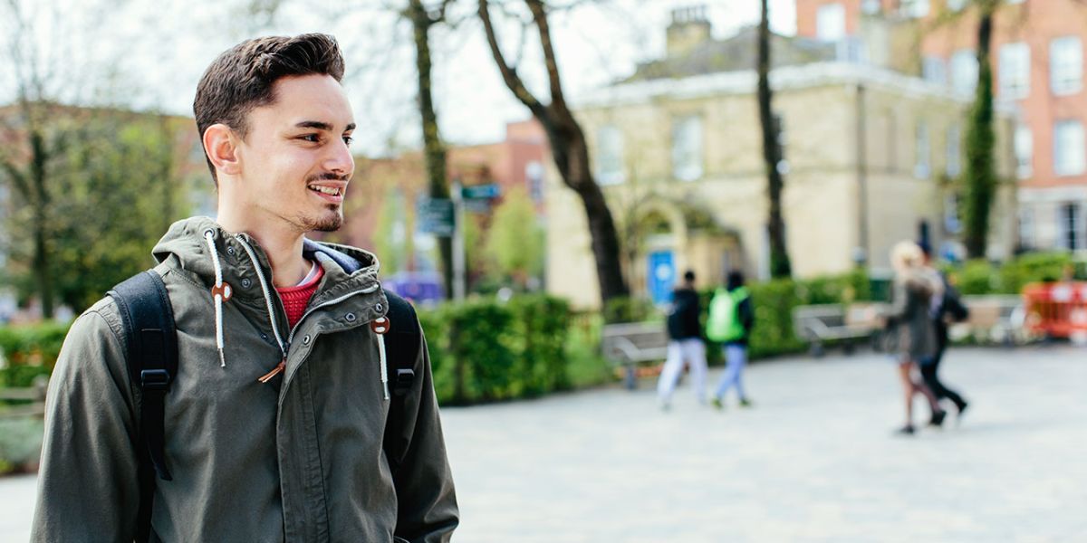 A student smiling outside the University