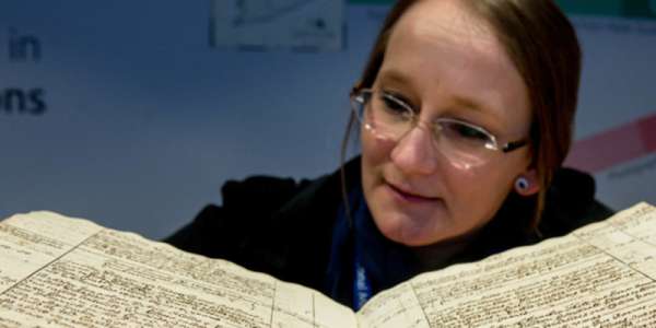 Photo of woman reading large medieval text