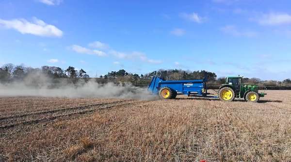 Tractor spreading rock dust in field trial