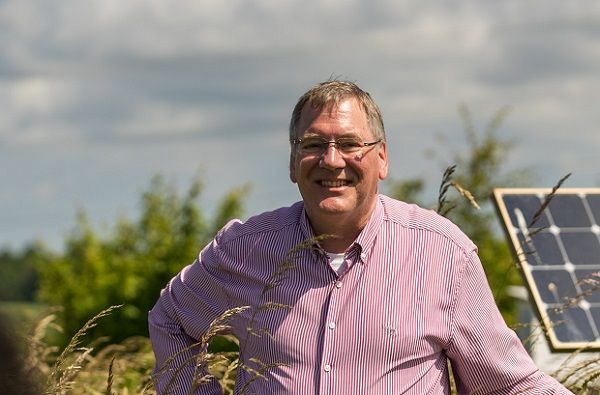 Professor Steve Banwart standing in a field with solar panels in the background