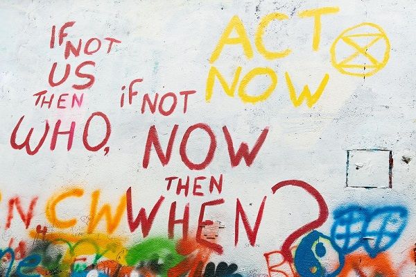 Colourful graffiti on a white wall about acting on climate change