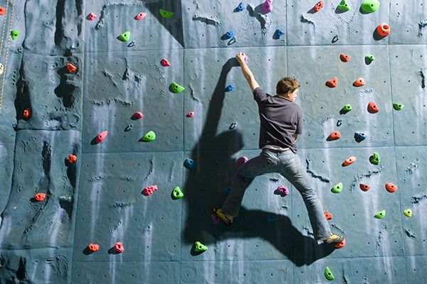 student climbing a climbing wall