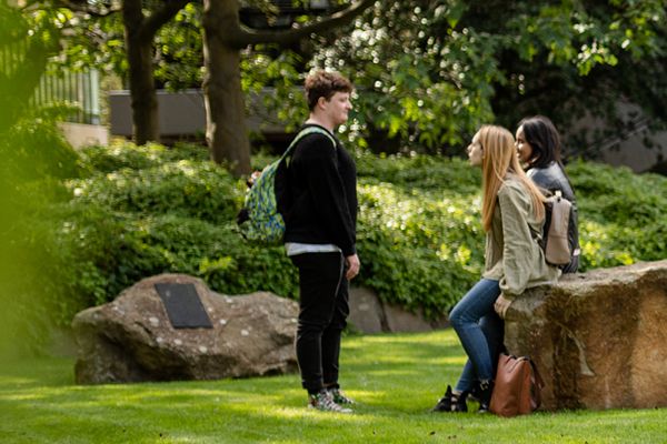 Three students in a park on campus