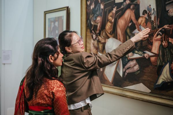 Two visitors to The Stanley and Audrey Burton Gallery discuss a painting close-up.