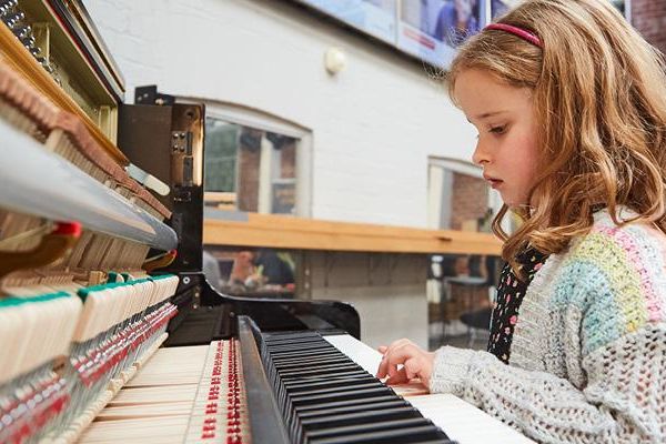 A child playing the piano at Be Curious