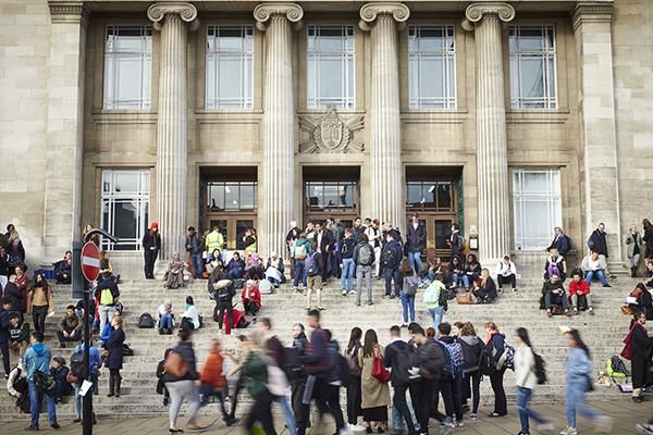 A crowd of people sitting and standing on the Parkinson Building steps.