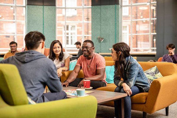 Four students sat around a table drinking hot drinks in the Leeds University Union.