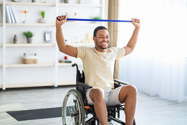 A wheelchair user exercising with resistance bands.