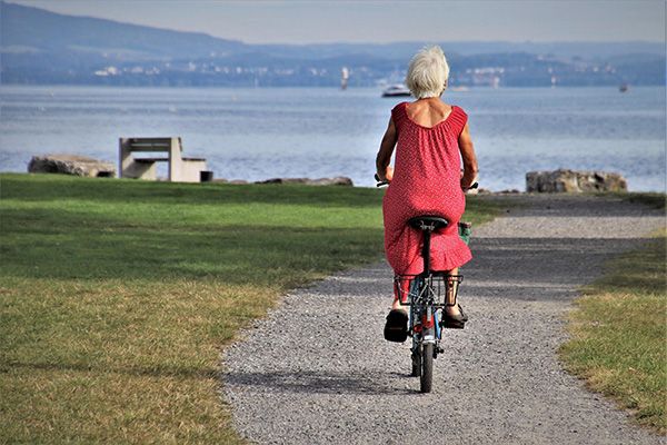 A woman on a bike cycling on a path.