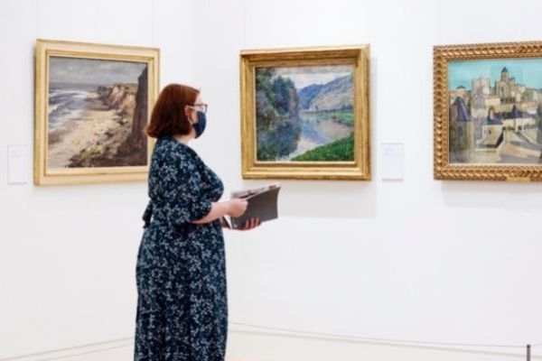 woman looking at paintings in gallery