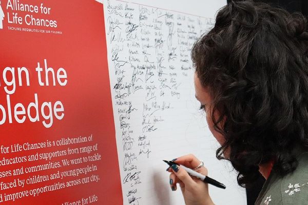 A delegate signs the pledge to try and end barriers to social mobility in Bradford