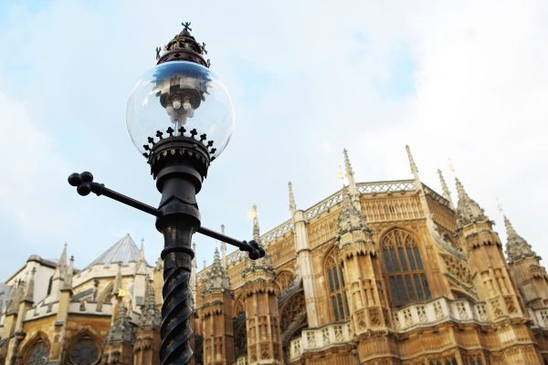 An unlit lamp in front of Westminster Hall, with a blue sky in the background