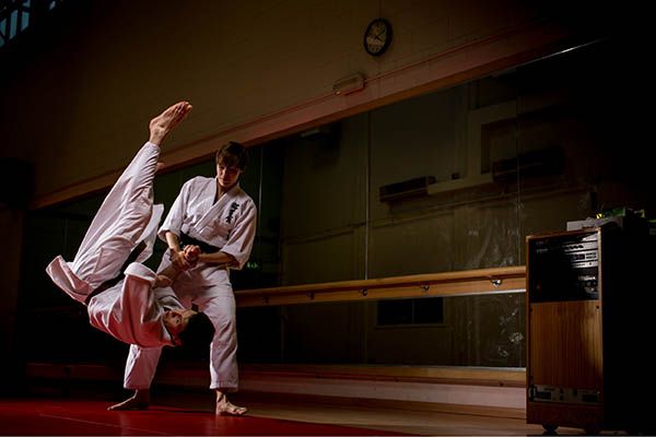 Two students exercising in a studio with karate.