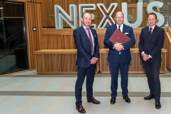 From left, Professor Nick Plant, Science Minister George Freeman and Dr Martin Stow standing in front of the Nexus logo in the building foyer