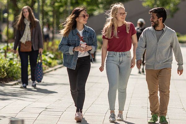 Three students walking together on campus.