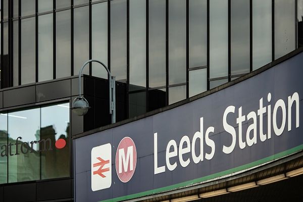 A sign saying Leeds Station above the main entrance to Leeds Train Station