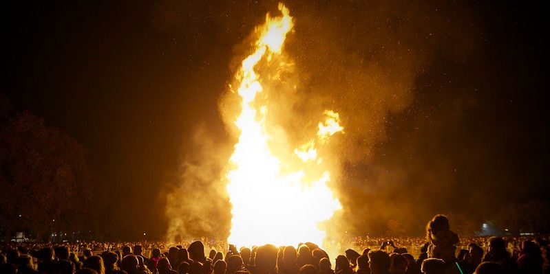 A large crowd standing around a bonfire