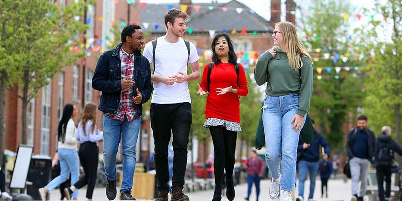 Four students walking together outside Leeds University Union.