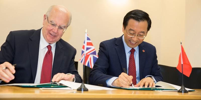 Alan Langlands and Jie Zhang signing documents