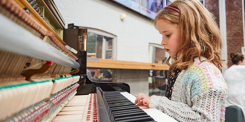 A child playing the piano at Be Curious