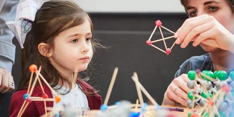 A child looking at a matchstick model at Be Curious