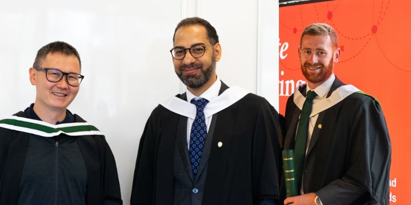 The image shows three graduates in their graduation gowns, looking at the camera and smiling. From left to right they are Gani Sultanov, Alaaeldin Aly and Ryan Kean