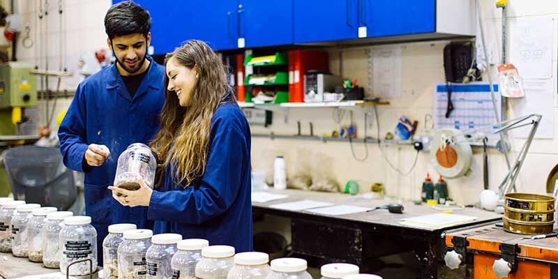 Two students working together and smiling in a Lab.