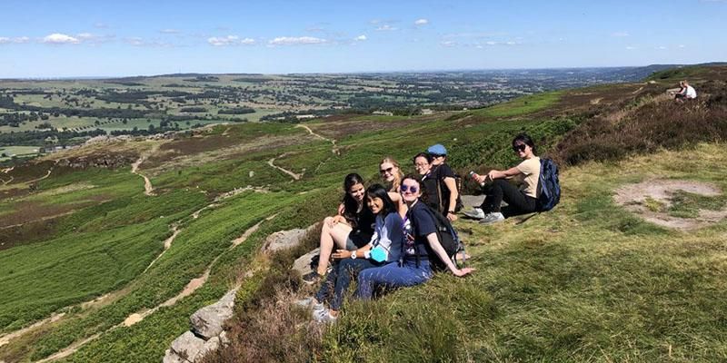 A group of Leeds International Summer School students sitting on Ilkley Moor