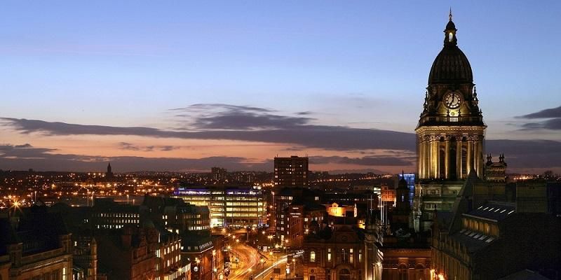 Skyline view of Leeds, featuring Leeds Town Hall and the streets below at sunset.
