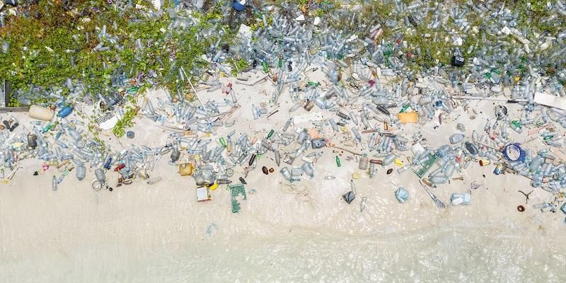 Aerial image showing discarded plastics washed up on a beach.