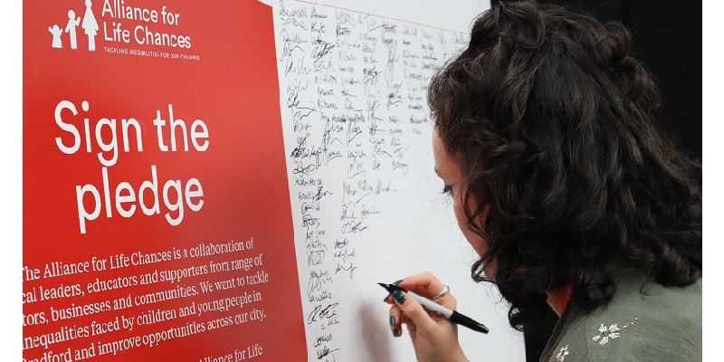 A delegate signs the pledge to try and end barriers to social mobility in Bradford