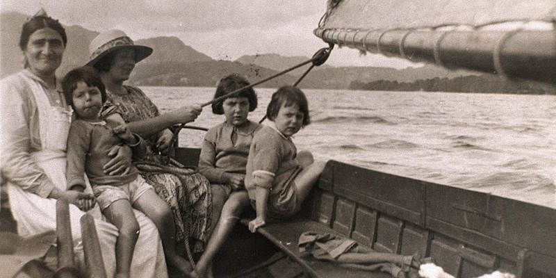 Mavis Guzelian (née Altounyan), the inspiration for Titty, on the lap of a nanny while boating on Coniston Lake in the early 1920s with her older sisters Taqui (l) and Susie and their maternal aunt Barbara. © Guzelian Ltd