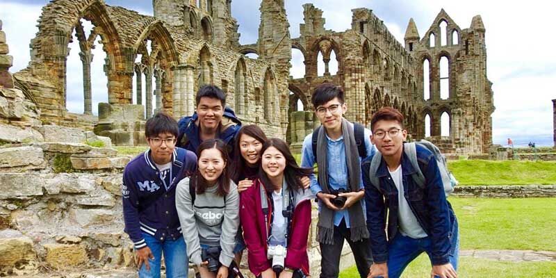 A group of students standing in front of Whitby Abbey.