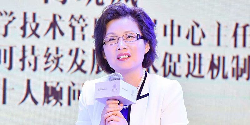Xiaolan Fu speaking into a microphone at a conference.