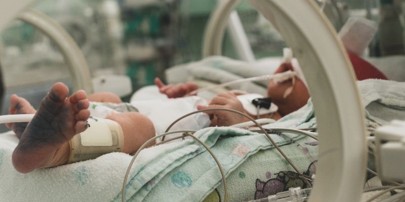 A newborn baby in an intensive care bed