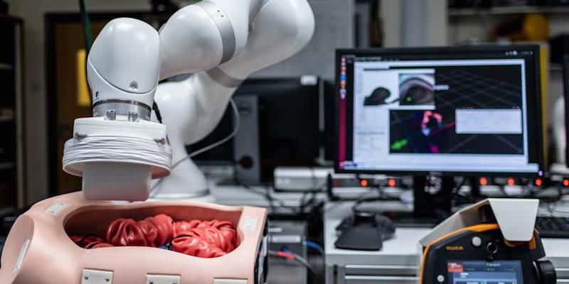 Robotic arm that can check for early signs of colon cancer next to a computer screen