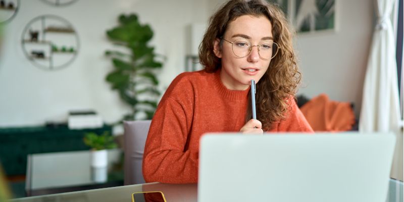 female student studying online sat in front of a laptop