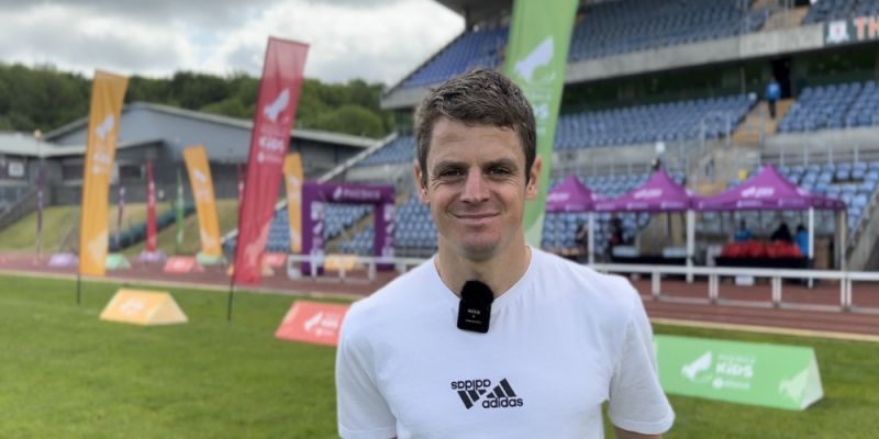 Profile image of Jonny Brownlee smiling in front of a stadium
