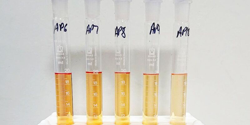 A row of test tubes with orange fluid on them