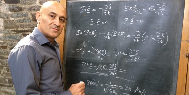 Professor Jim Al-Khalili writing on a chalkboard.