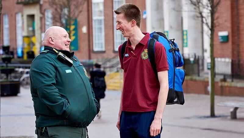 A medical student talking to a Community Defibrillation Officer from Yorkshire Ambulance Service outside Leeds University Union.