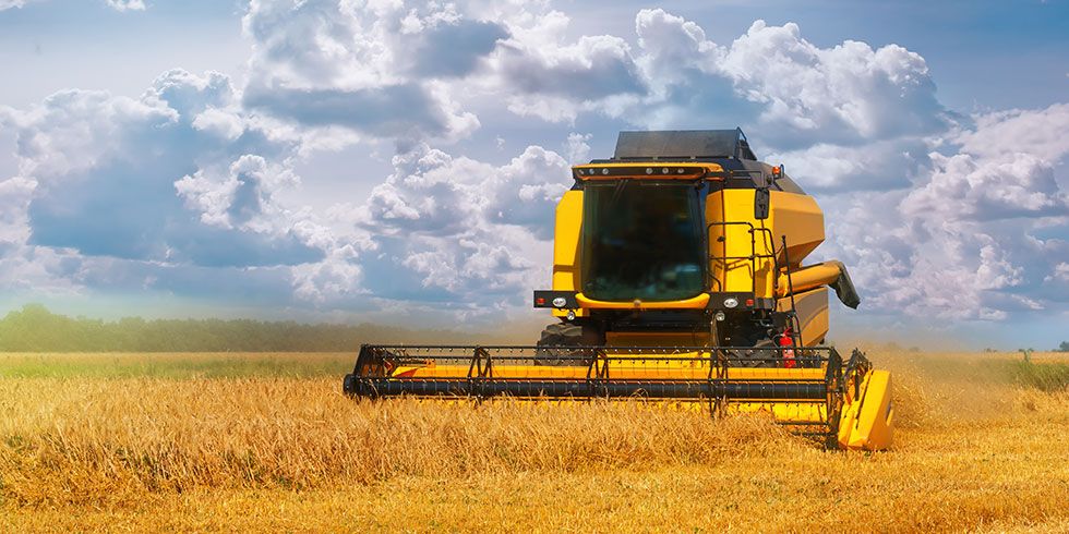 A combine harvester, harvesting crops in a field.